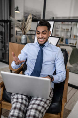 Gesturing man working on laptop while sitting at home