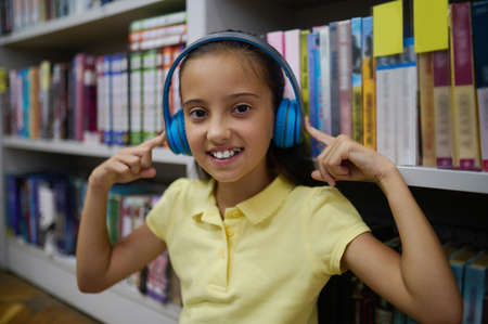 Smiling cheerful adolescent girl listening to favorite musicの写真素材