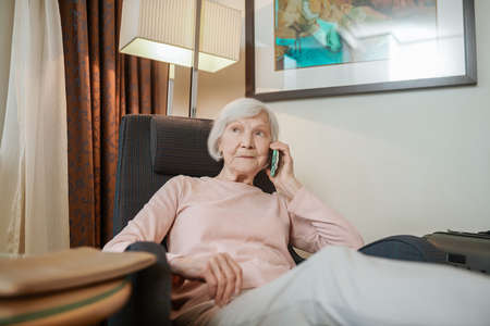 Short-haired elegant lady talking on the phone