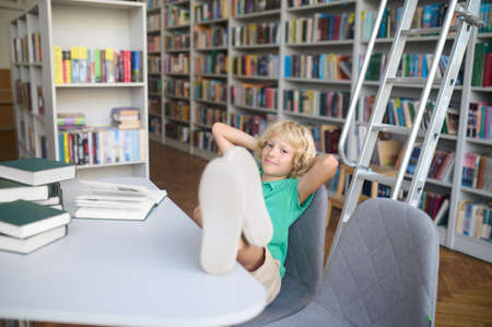 Schoolboy taking a break from reading books