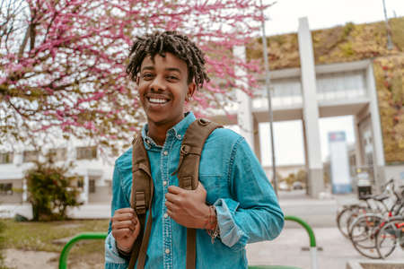 Guy confidently smiling at camera standing on street