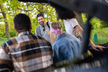 Group of young people sitting near the acr and talkingの写真素材
