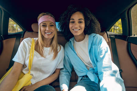 Two cute young women sitting in the carの写真素材