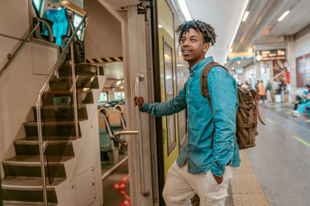 Guy holding handrail entering train carの写真素材