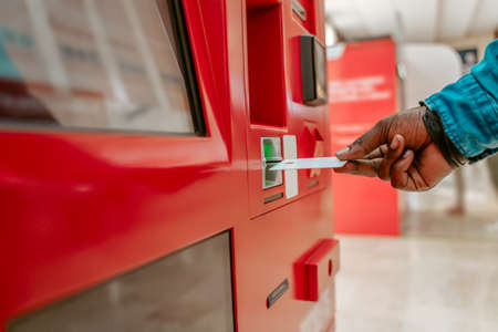 Hand holding card near terminal slotの写真素材
