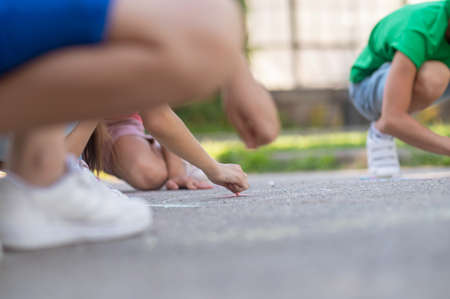 Children painting on asphalt, no faceの写真素材