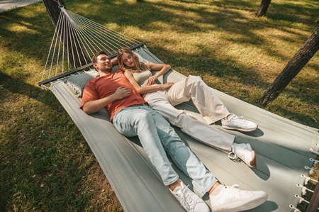 Young couple lying in hammÑck and looking peaceflの写真素材