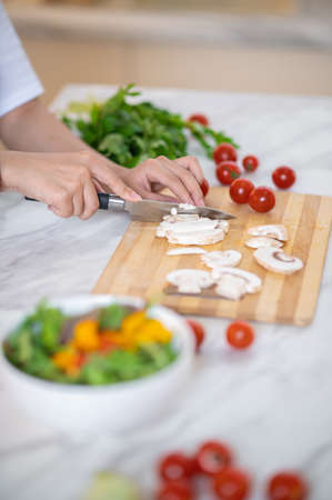Close up of females hands cutting veggiesの写真素材