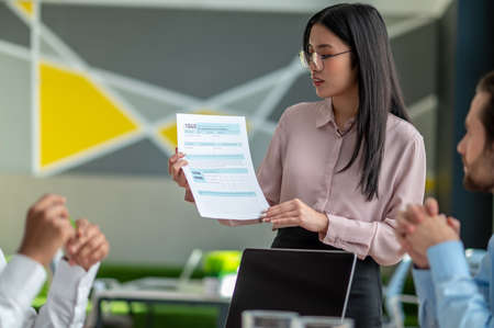 Long-haired brunette talking with business partners in the office