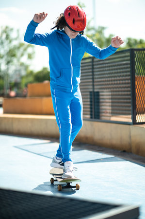 Teenager in a protective helmet practicing his skateboarding skills