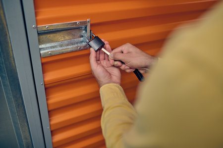 Male employee locking the storage unit doorの写真素材