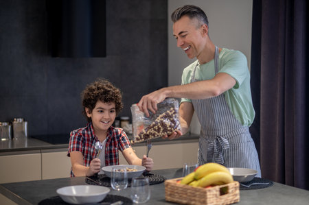 Family having breakfast together and looking happyの写真素材