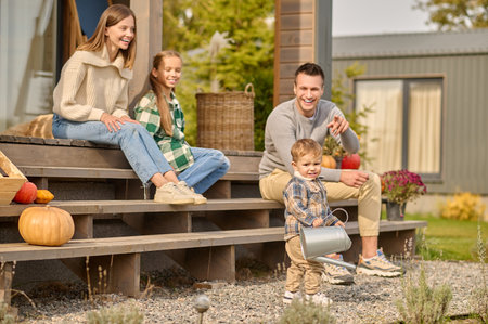 Happy modern family of four people resting on the verandaの写真素材