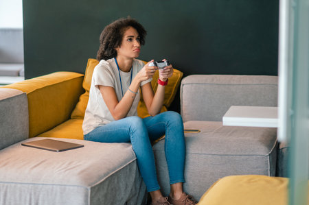 Cute young woman looking involved while playing on gamesの写真素材