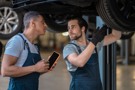 Skilled mechanics checking tires on the customer vehicleの写真素材
