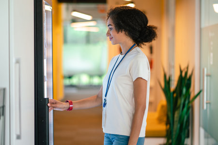 Young woman choosing something from the fridge in the office canteen
