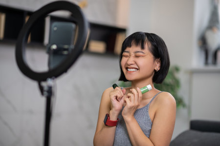 Young video blogger enjoying filming her skin care tutorialの写真素材