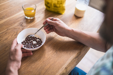 Mature caucasian man sitting at the table and eating breakfastの写真素材