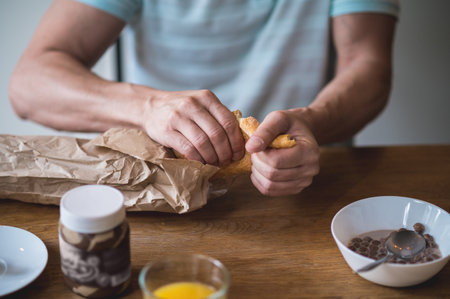 Close up picture of man breaking bread for sandwiches