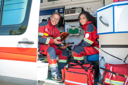 Cheerful paramedics posing for the camera in the ambulance carの写真素材