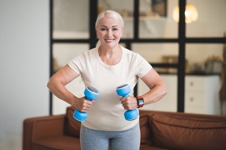 Cheerful lady exercising with hand weights indoors