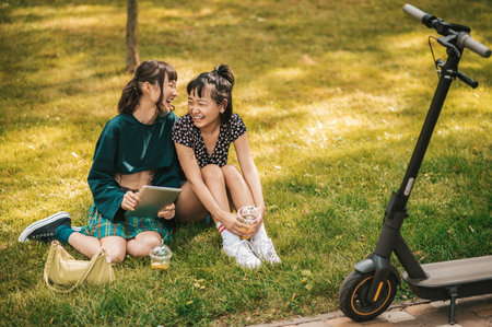 Two girls sitting on a lawn and looking peaceful and enjoyedの写真素材