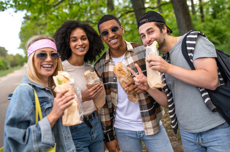 Young people eating sandwiches and looking joyfulの写真素材