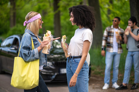 Young people eating sandwiches and looking joyfulの写真素材