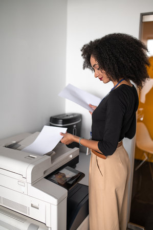 Dark-haired well-dressed woman making copies