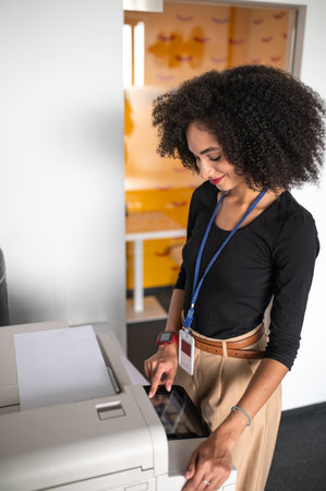 Dark-haired well-dressed woman making copies
