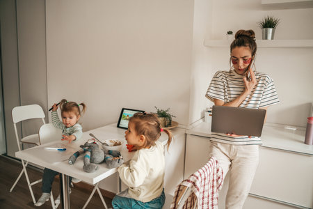Busy female freelancer and her kids in the kitchenの写真素材