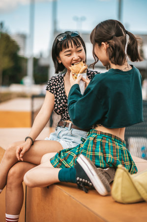 Pretty young girls enjoying the good weather and street foodの写真素材