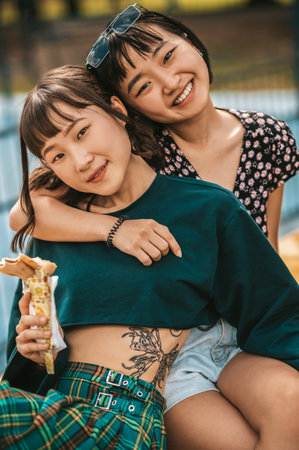 Pretty girls hugging each other and looking happyの写真素材