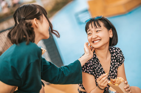 Cute dark-haired girl touching her girlfriends cheek with tendernessの写真素材
