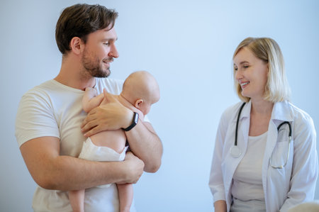 Young father receiving a medical consultation from an experienced pediatricianの写真素材