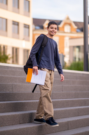 Smiling boy descending the concrete stairs outsideの写真素材