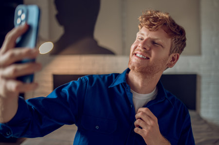 Smiling ginger man making selfie and looking confidentの写真素材