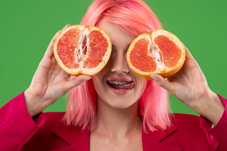 Hungry girl posing with citrus fruit during the photo shootの写真素材