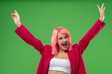 Excited extravagant girl posing for the camera in a studioの写真素材