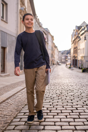 Joyous teenage boy walking along the roadの写真素材