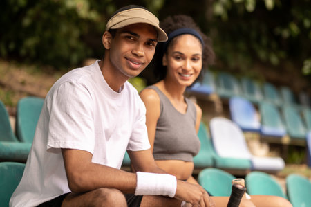 Two young tennis players smiling and looking happyの写真素材