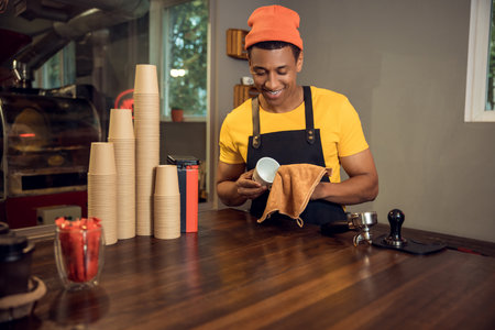 Cheerful young barista working in a cafeの写真素材