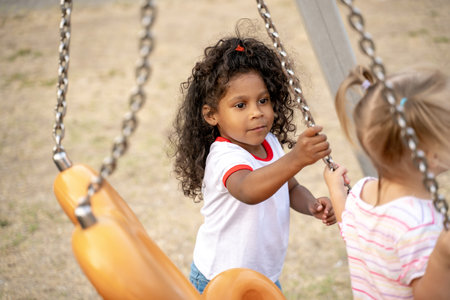 Cute kid playing with her friend outdoorsの写真素材