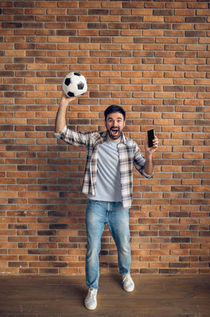 Football amateur posing for the camera against the brick wallの写真素材