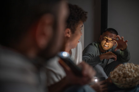 Company of buddies sitting in the darkの写真素材