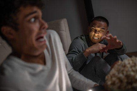 Male scaring his friend in a dark room