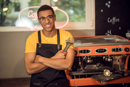 Cheerful coffee machine technician posing for the camera at workの写真素材