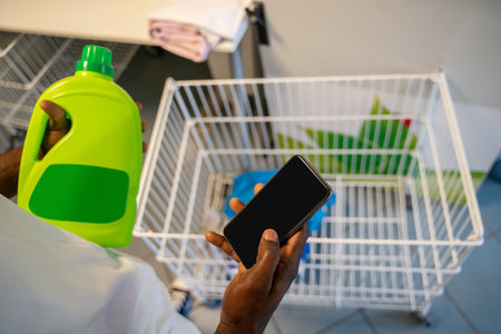 Male with a cellphone in hands at a self-service launderetteの写真素材