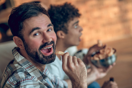 Male treating his friend with a snackの写真素材