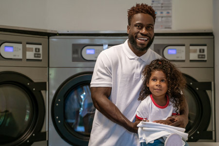 Joyous male and his daughter at the launderetteの写真素材